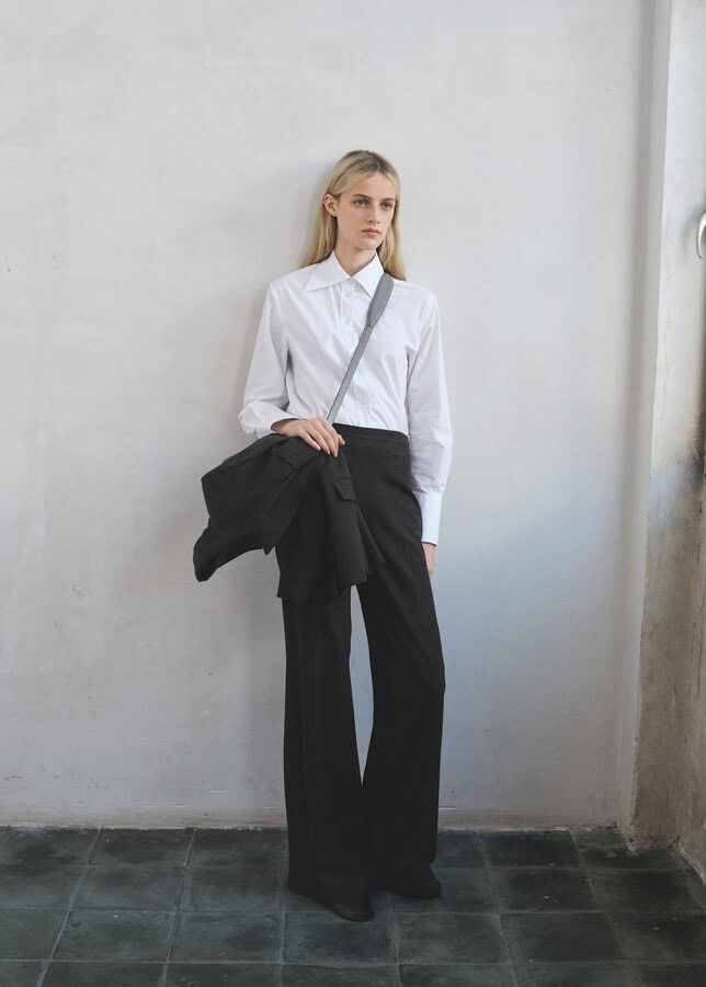 Slim-fit navy pinstripe trousers with a mid-rise waist and straight tailored legs.