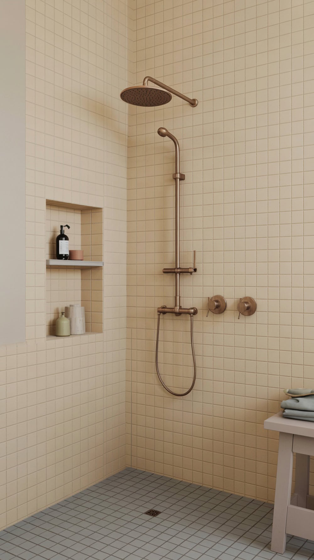 A modern shower nook with beige tiles, a stylish showerhead, and a built-in shelf for toiletries.
