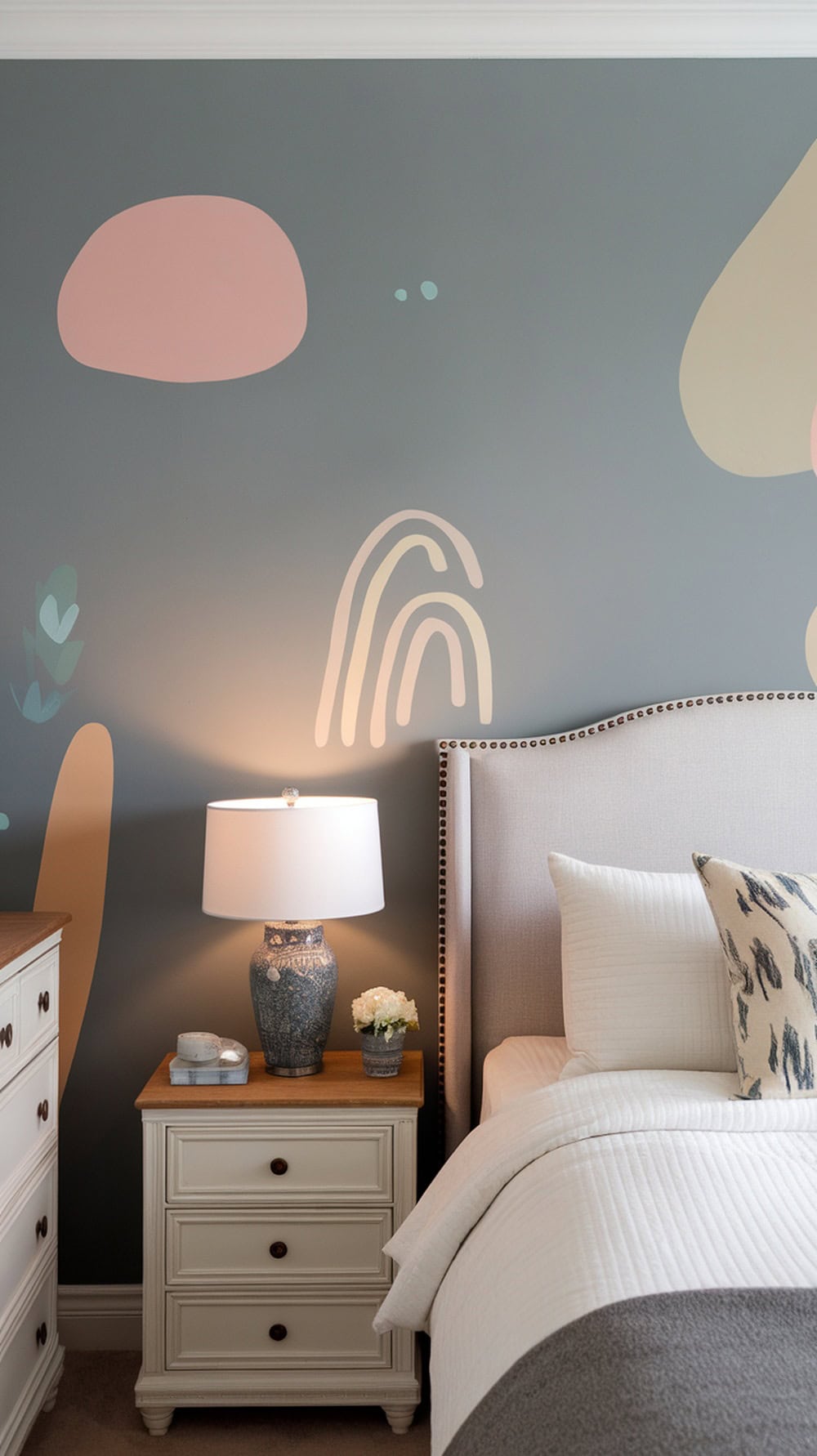A cozy bedroom with soft colors and playful wall art.