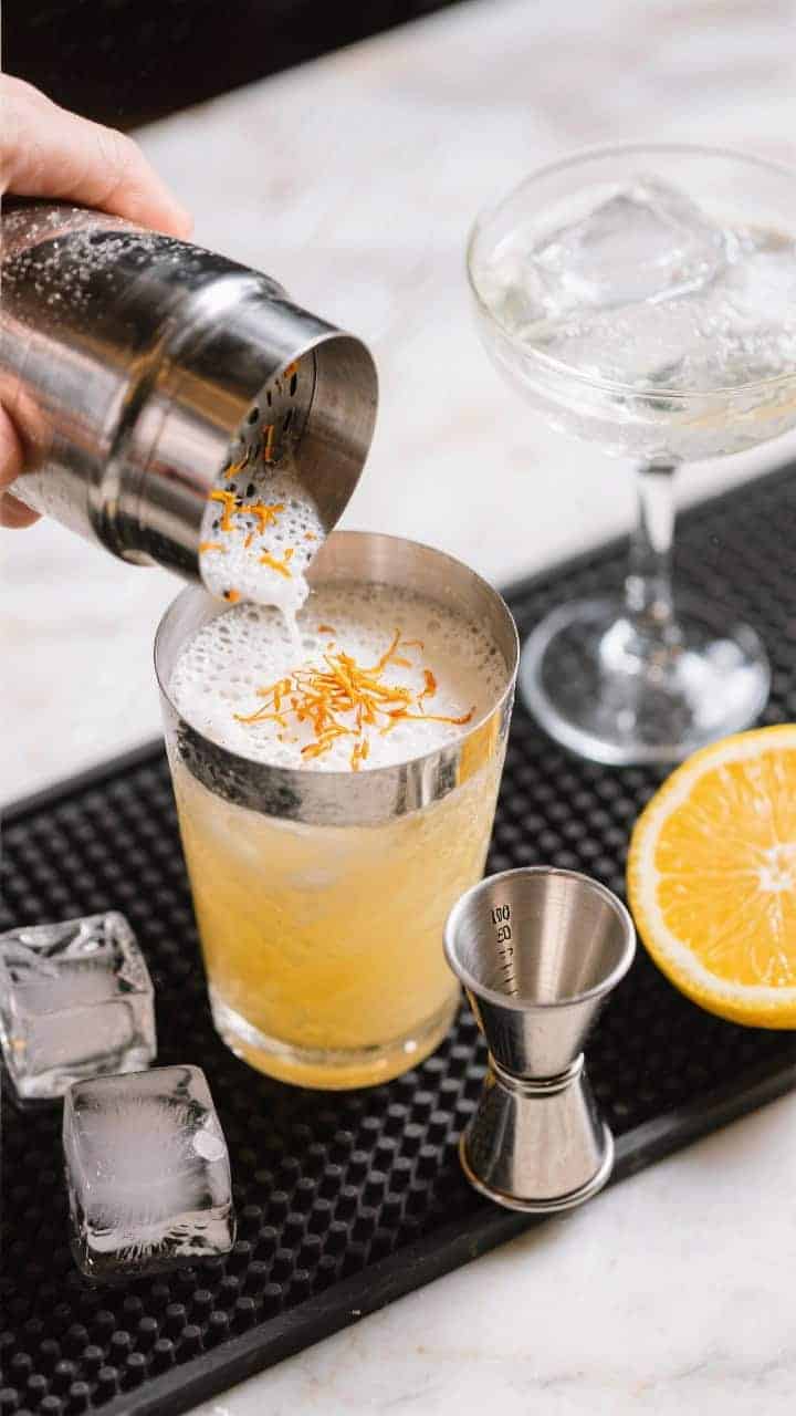 Cooking process: Overhead shot of the cocktail shaker just opened after a vigorous shake, showing th