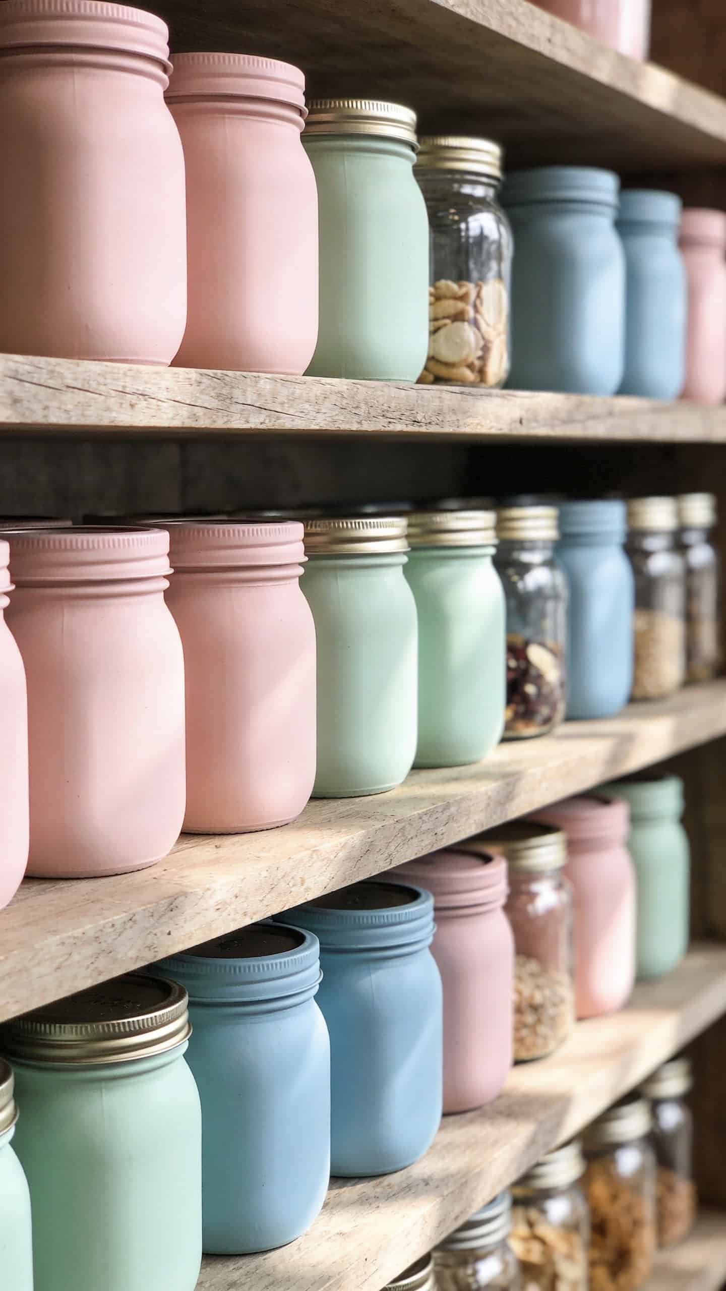 mason jars painted in soft pastel tones used for storage on shelves