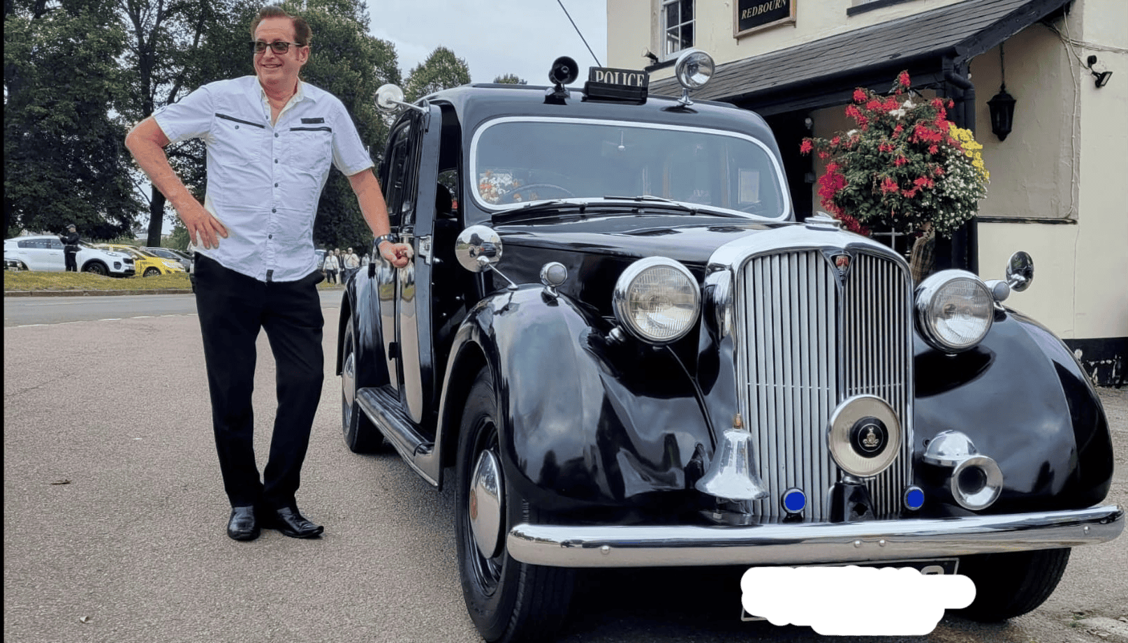 Alex standing proudly near his vintage car.