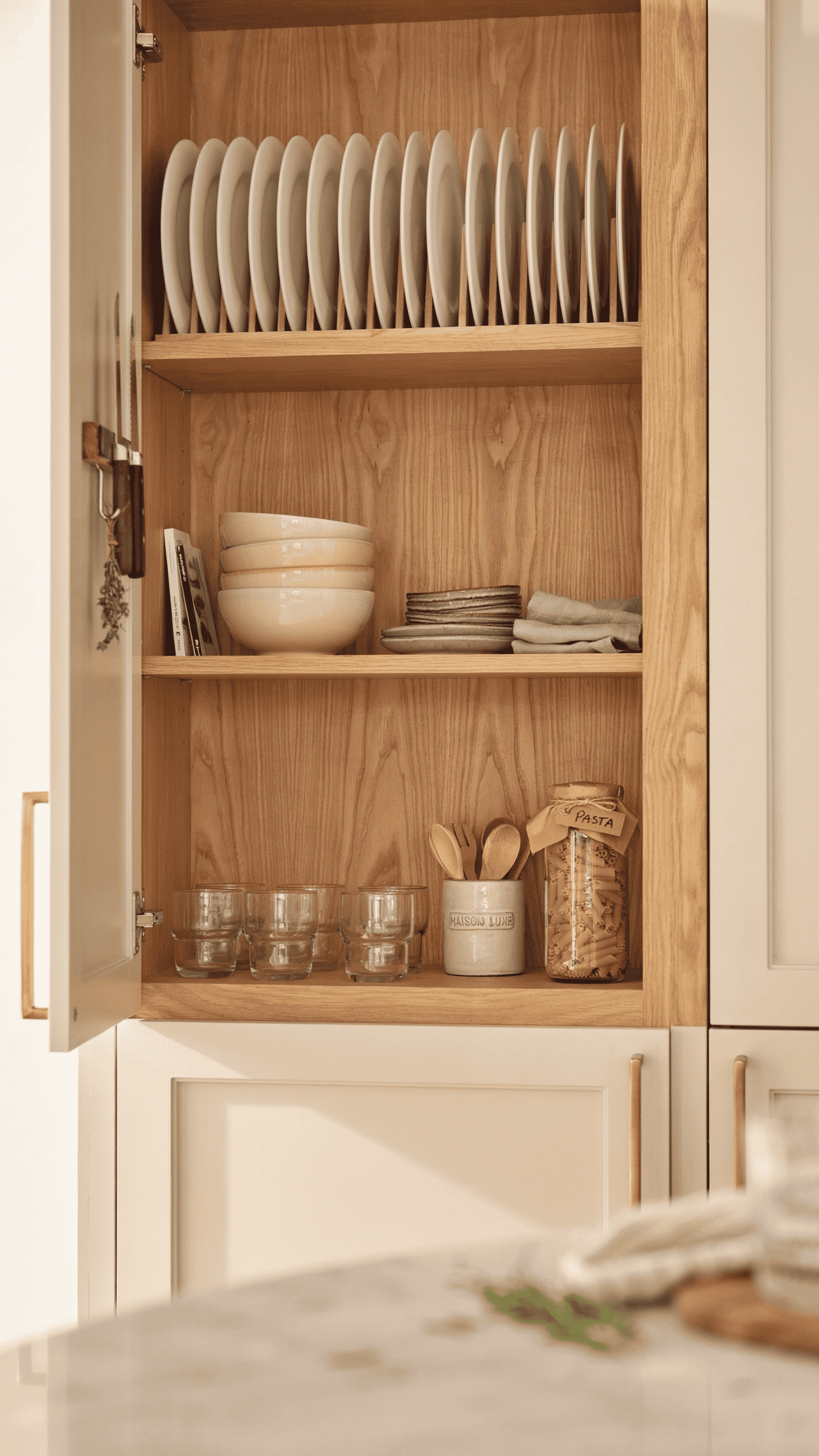 Organized kitchen cabinet with neatly stacked dishes and decluttered shelves.
