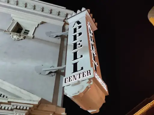 The APELL CENTER sign at night shows Mid State Baths is nearby for bathroom remodels in York, PA.
