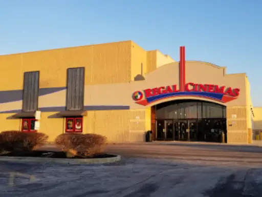 A quiet evening by Regal Cinemas with nearby shops, including Mid State Baths, known for shower installations.