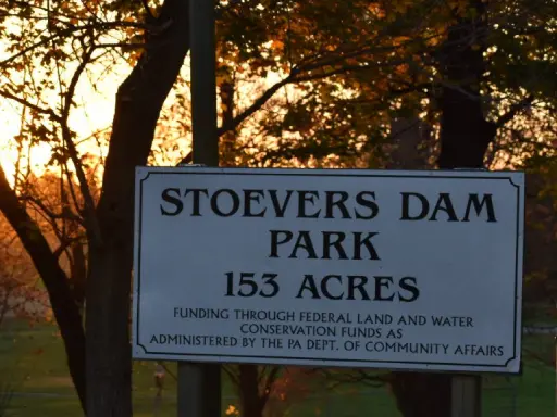 A sign for Stoevers Dam Park shows its size and mentions how it is managed. The park is located near Mid State Baths in Carlisle.