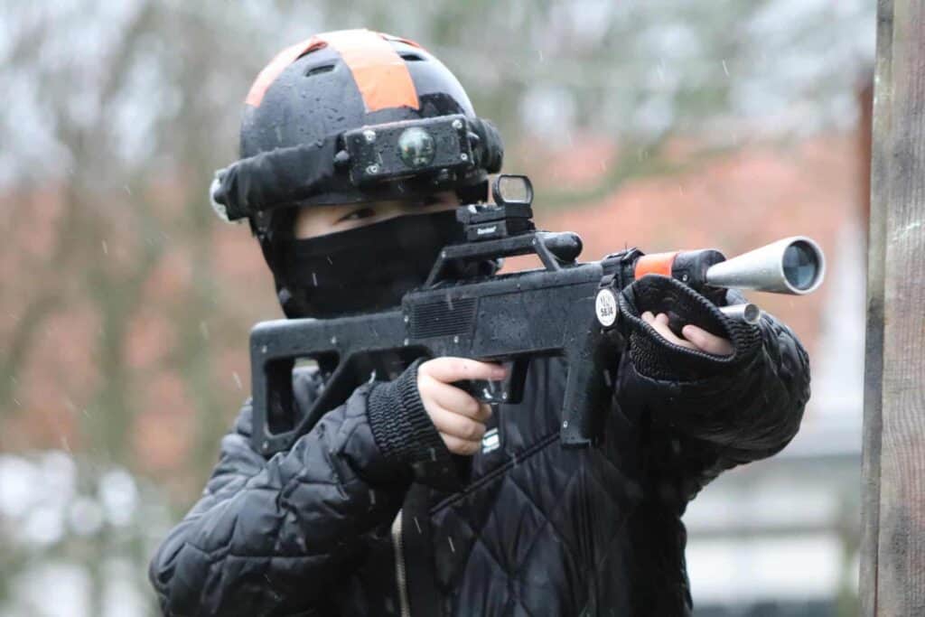 Dreng spiller paintball i regnen
