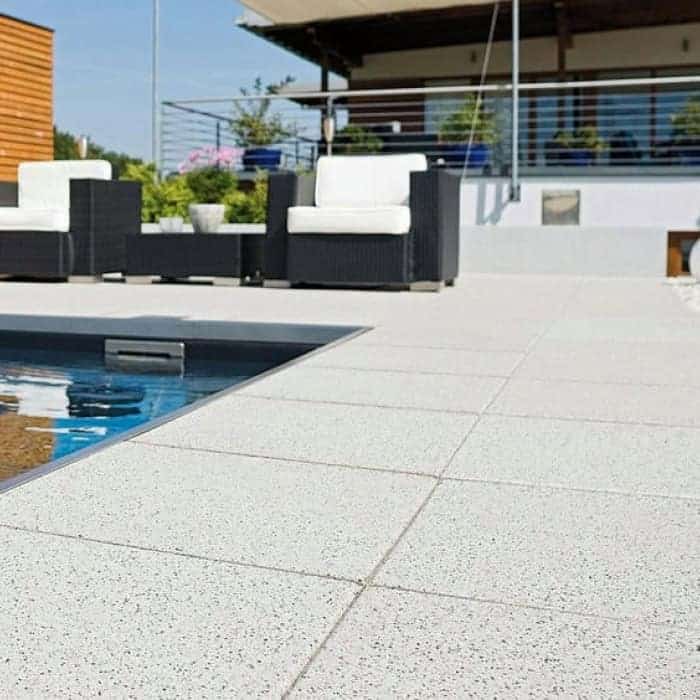 Outdoor poolside patio with modern seating and terrace railing for relaxation.