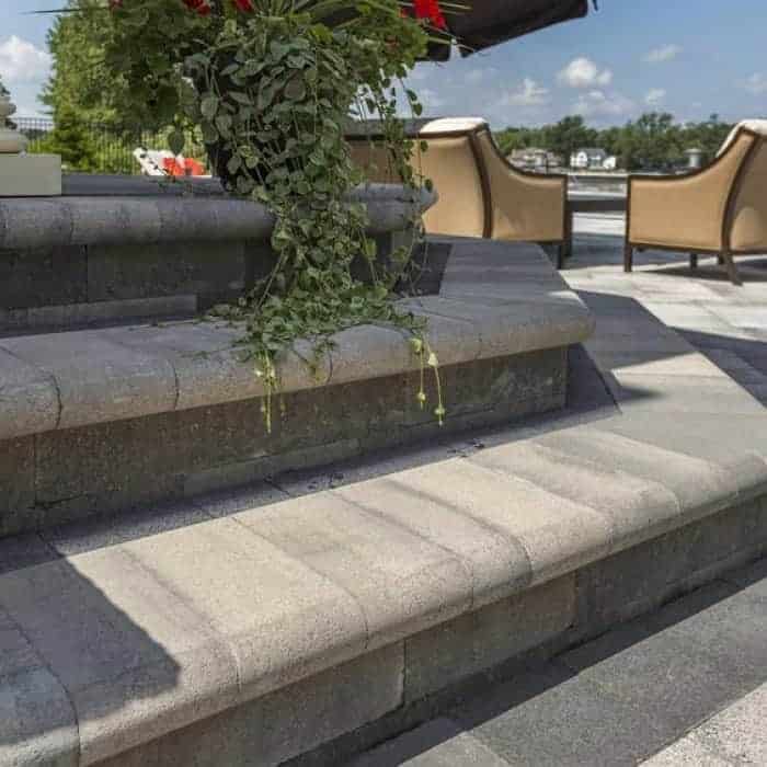 Outdoor stone staircase with plants and seating area.