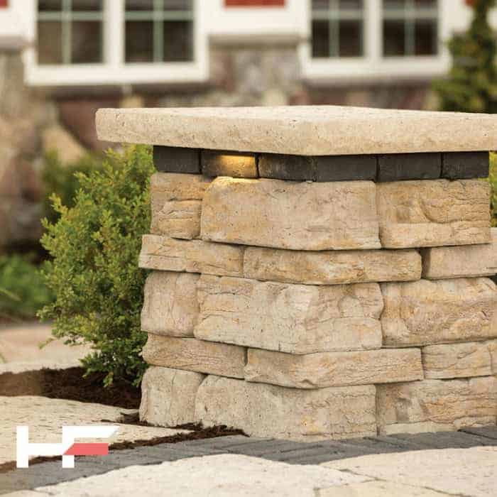 Close-up of a stone garden wall with a concrete cap, outdoors.