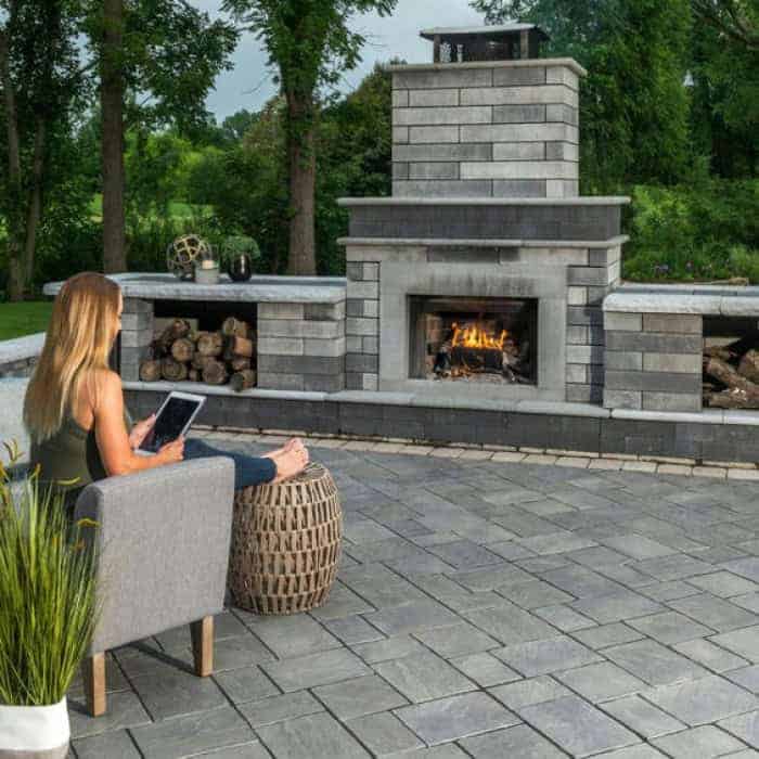 Outdoor fireplace with seating and firewood storage for cozy outdoor gatherings.