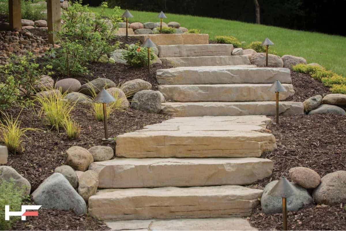 Stone garden pathway with outdoor lighting and landscaping elements.