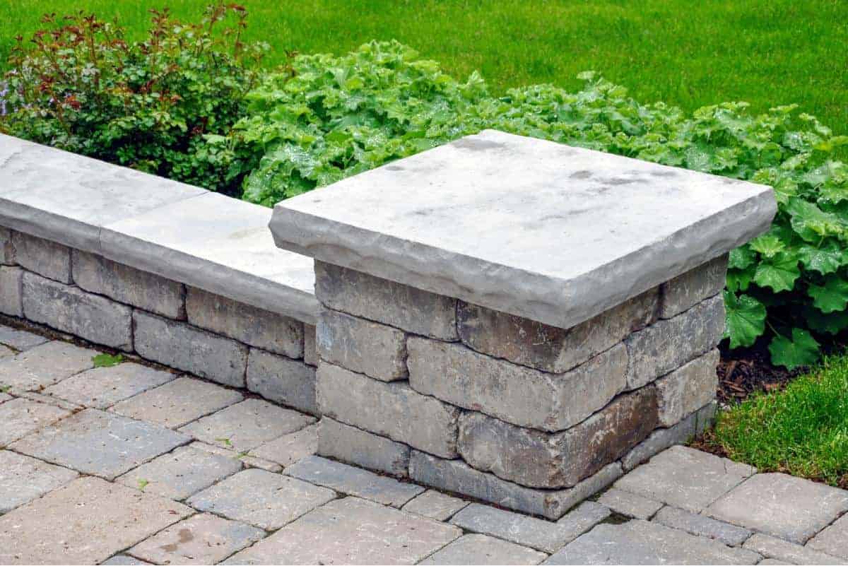 Stone garden border with concrete cap for lawn edging and landscape design.