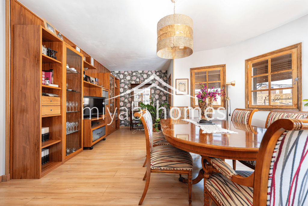 Gemütliches Esszimmer mit Holzregalen und Blick auf den Garten.