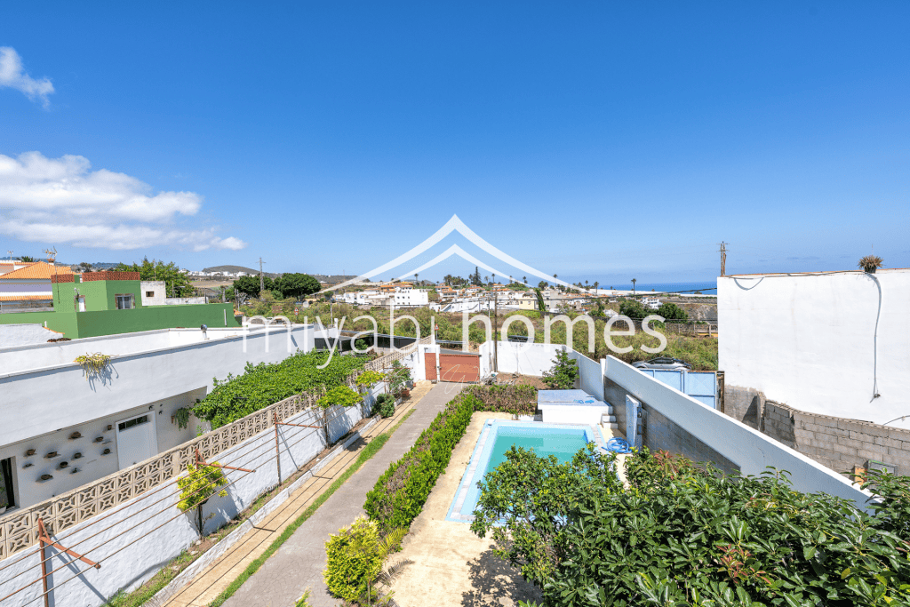 Blick auf den Garten und Pool eines Hauses in Gran Canaria mit Meer- und Bergblick.