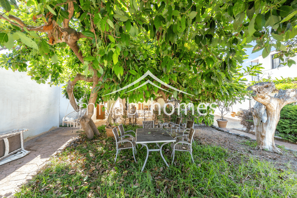 Gemütlicher Garten mit Esstisch unter Bäumen in Gran Canaria.