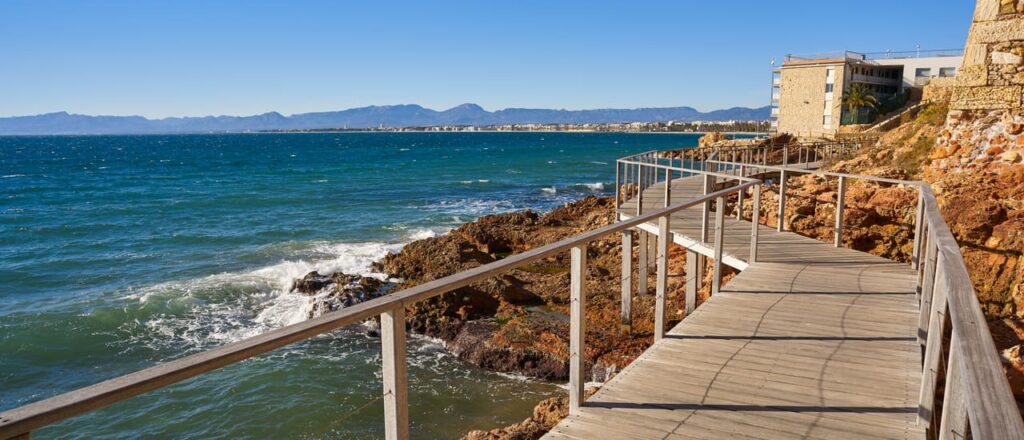 Pasarela costera sobre el mar azul y rocas