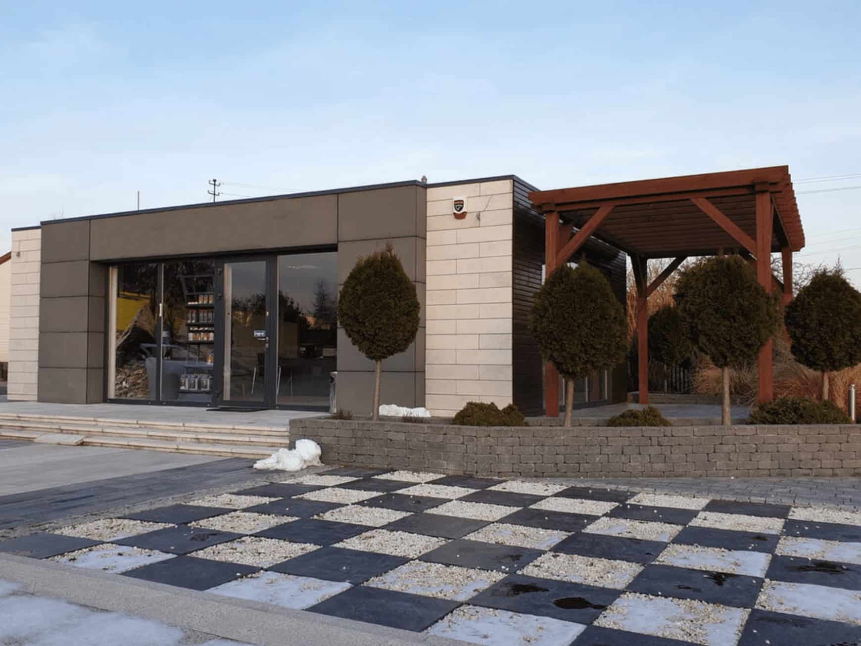 Edificio moderno con suelo ajedrezado y pérgola