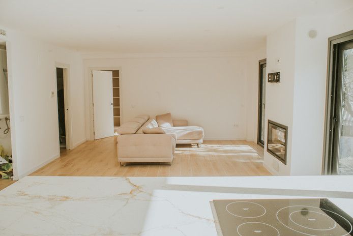 Sala de estar moderna con chimenea y sofá beige.