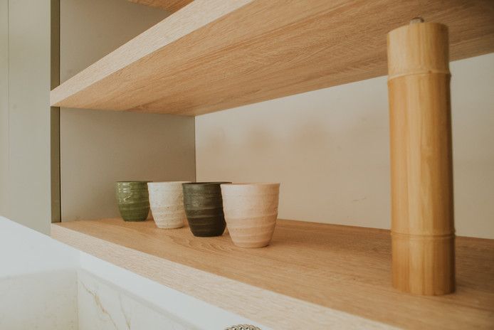 Estantería de madera con tazas de cerámica.