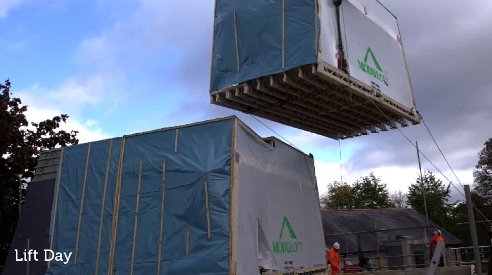 Modular building lift day at a construction site with blue and grey structures.