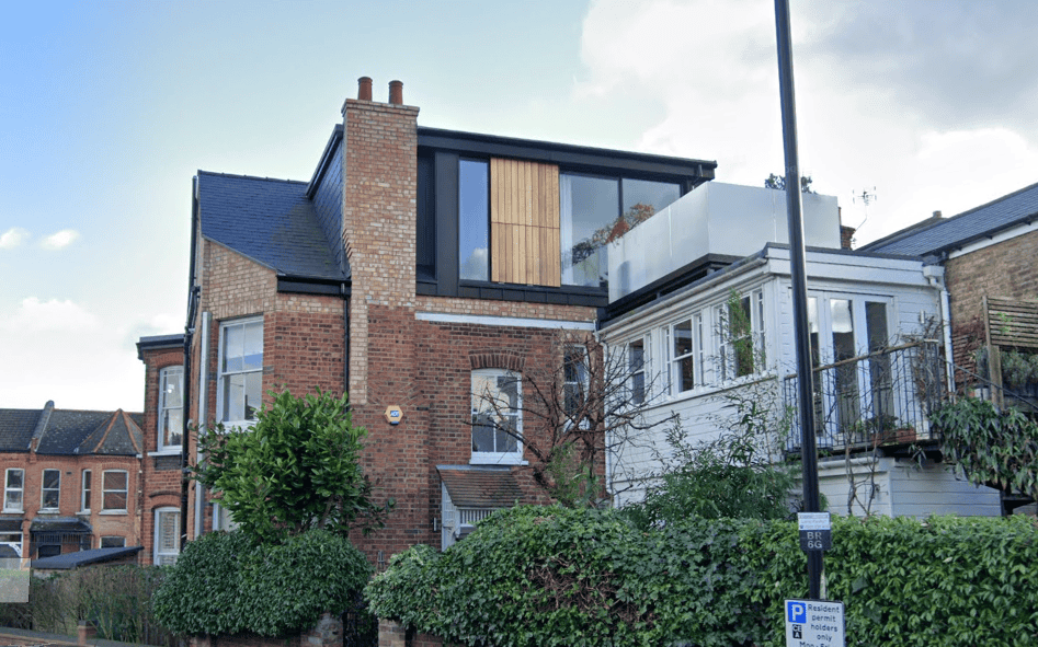 Modern brick house with a contemporary Moduloft extension and balcony in a high end residential area.