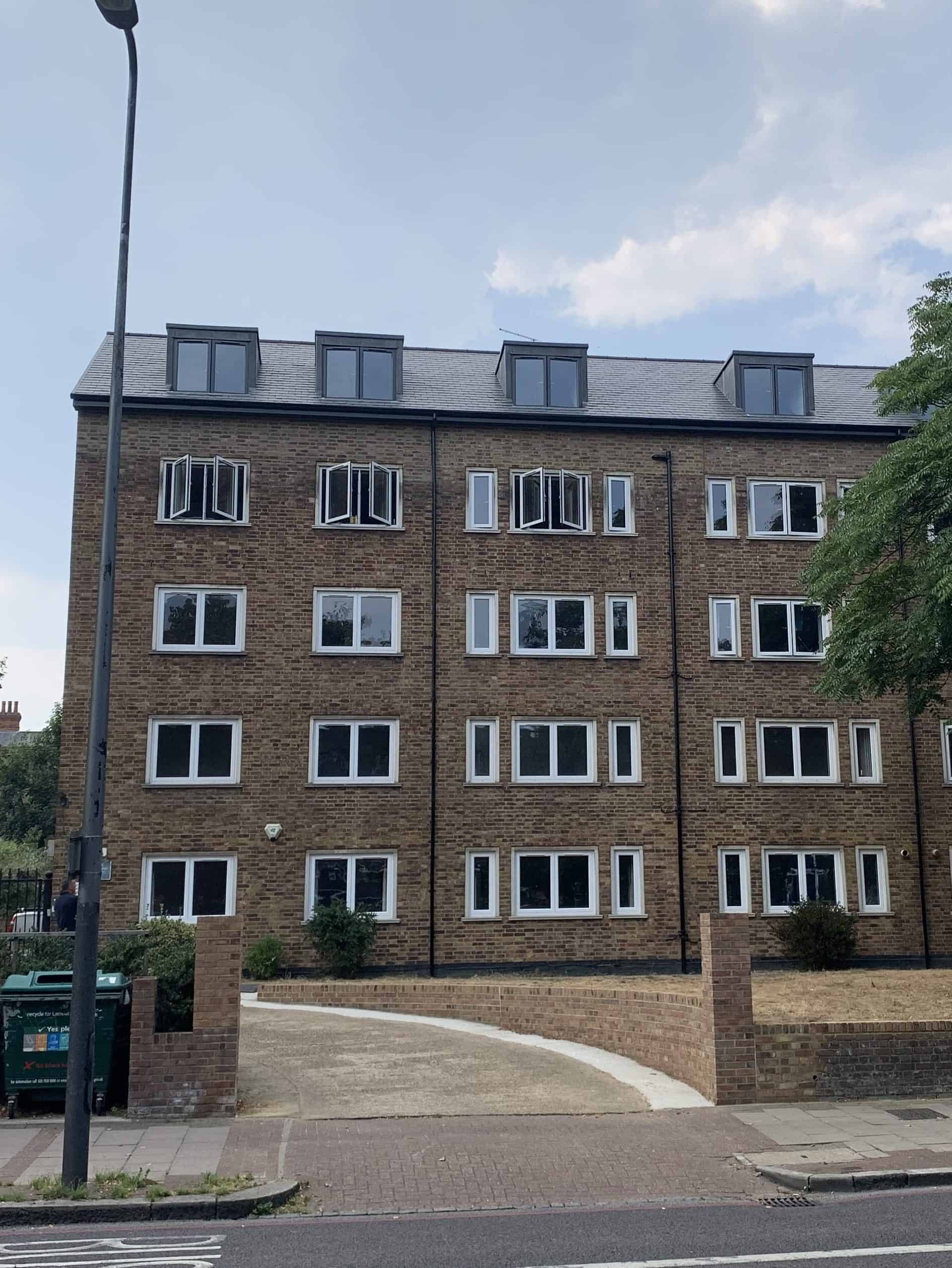 Modern brick apartment building with multiple windows and dormer roof.