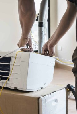 vecteezy_man-is-installing-air-conditioner-in-housing-unit-during-hot_9295440-scaled.jpg