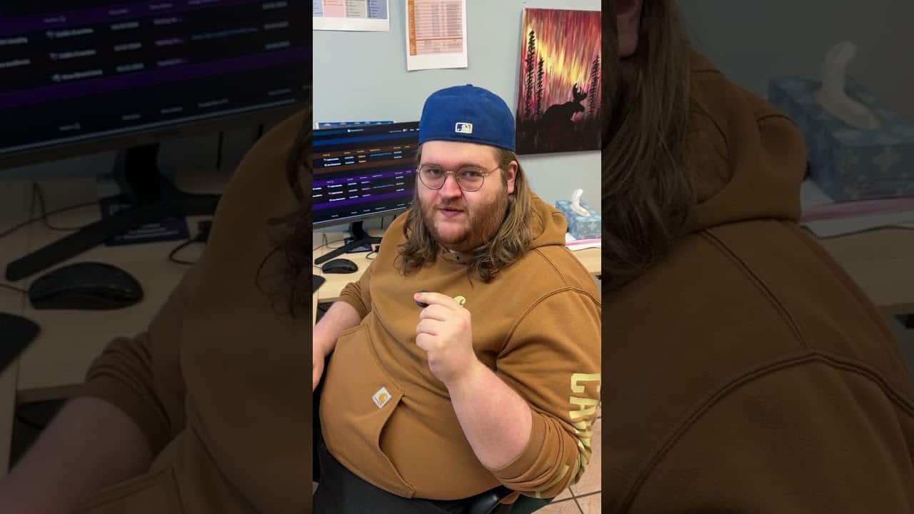 Man working at computer in office, MooseMedia branding visible, digital media production, creative workspace, MooseMedia FSJ.