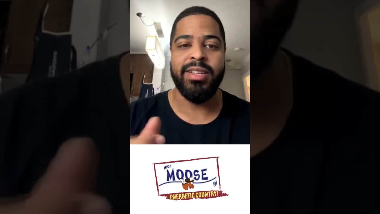 Vibrant man speaking in a video promoting MooseMedia, a radio station known for energetic country music broadcasts.