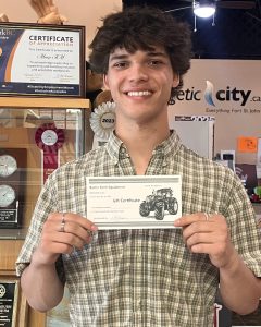 Certified young man holding a gift certificate for farm equipment at MooseMedia FSJ.