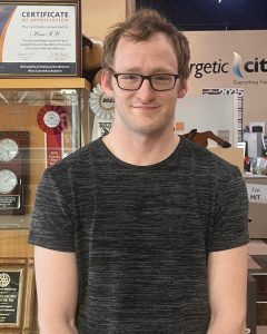 Professional young man wearing glasses smiling at MooseMedia event.