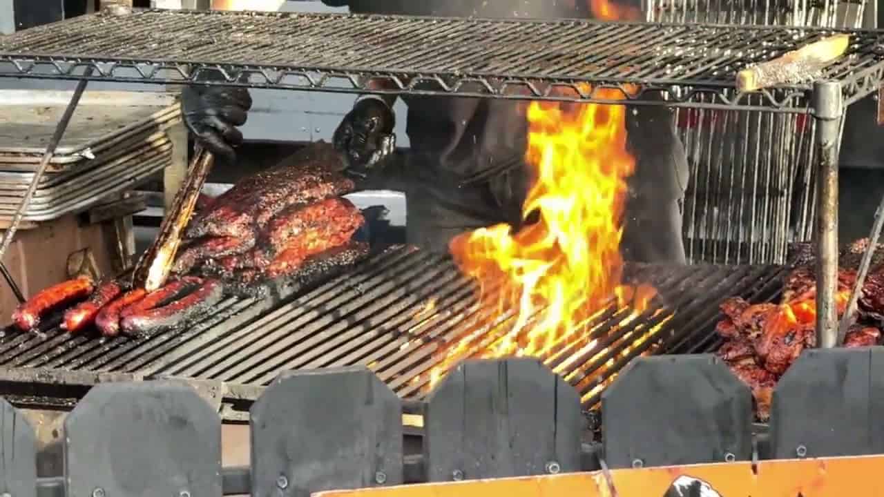 Juicy barbecue meats grilling over open flame at MooseMedia.
