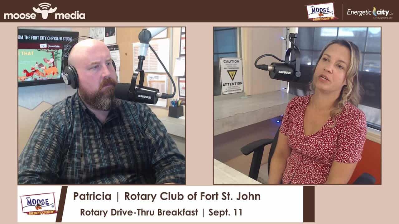 Microphone podcast interview at Moose Media Fort St. John community event.