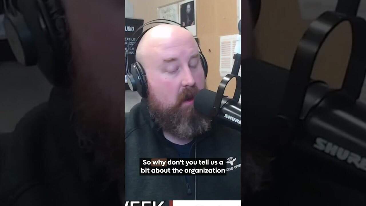 Professional radio host speaking into microphone at Moose Media studio, delivering engaging content.