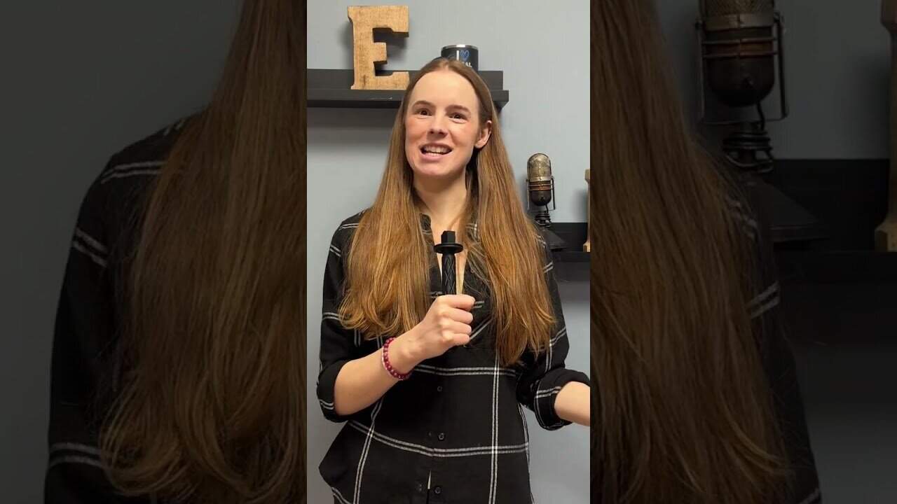 Young woman smiling and speaking with a microphone in a studio.