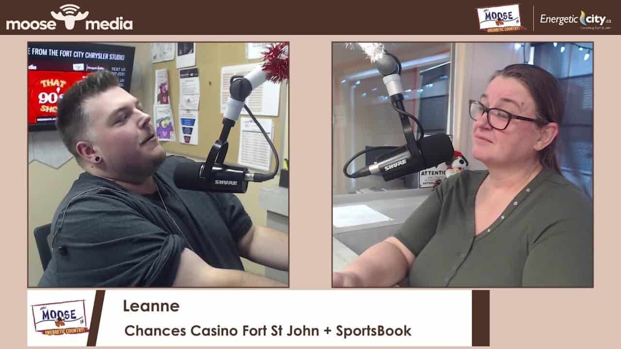 Two people speaking into microphones in a radio studio.