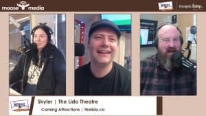 Radio hosts smiling during a live broadcast at The Lido Theatre.