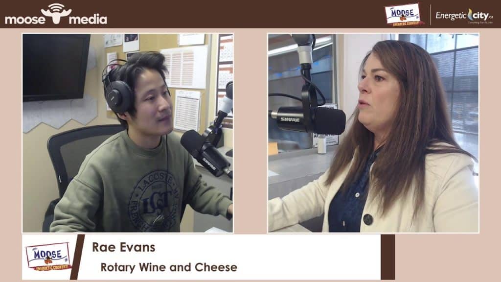 Two women speaking into microphones at Rotary Wine & Cheese event.
