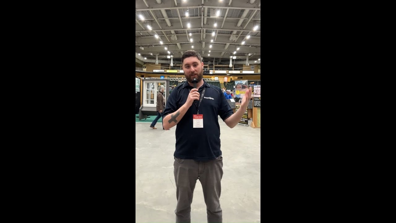 MooseMedia team member presenting at trade show in a large indoor venue.