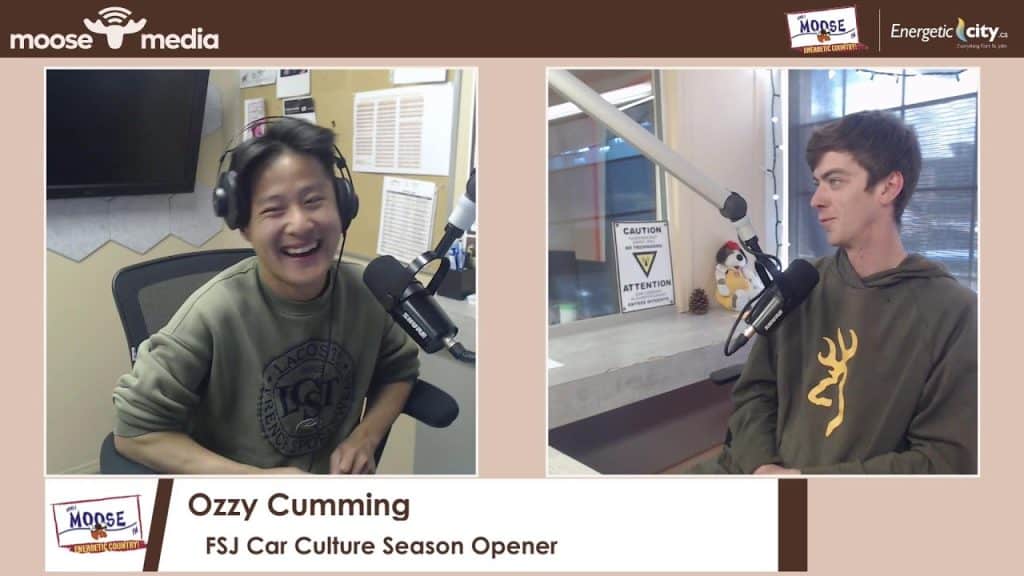 Ozzy Cumming speaking into microphone during radio interview.