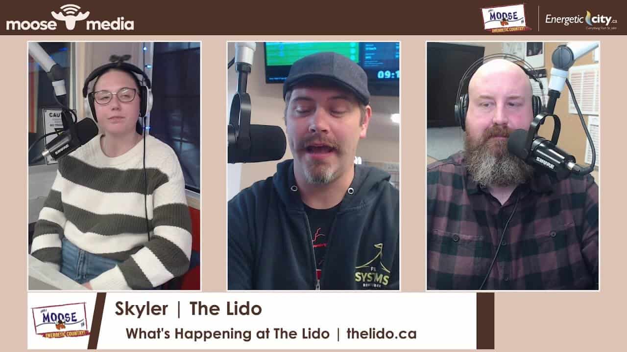 Skyler, the host, speaking into a microphone during a podcast recording at The Lido Theatre.