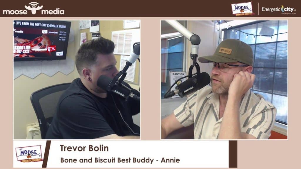 Two men in a radio studio with microphones, discussing on air.