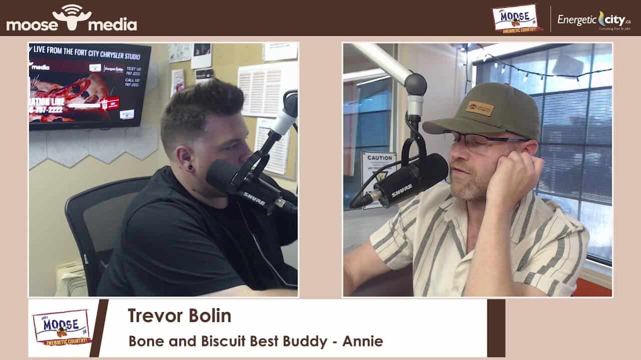 Two men in a radio studio with microphones, discussing on air.
