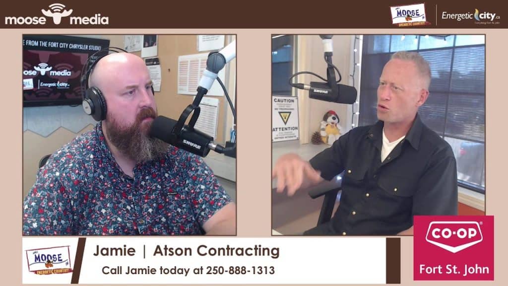 Two men in a radio studio engaged in conversation during a broadcast.