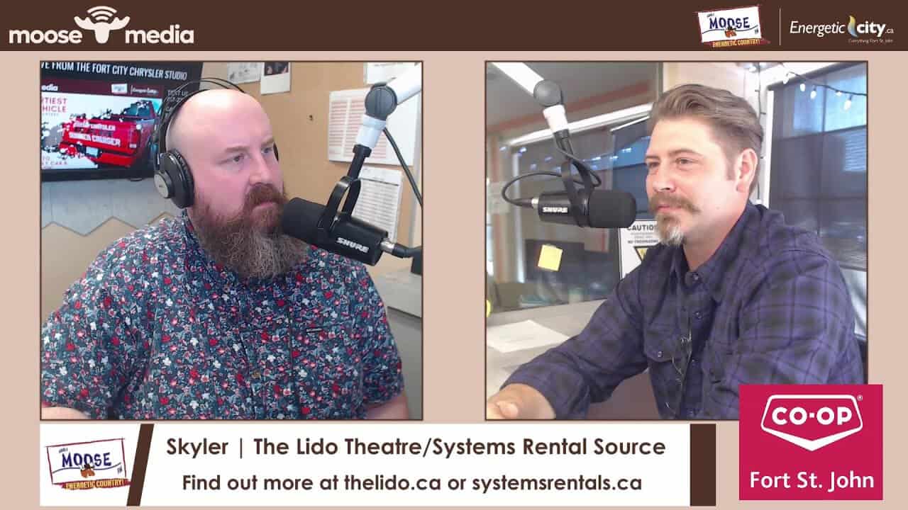 Two men recording a podcast at The Lido Theatre with microphones and headphones.