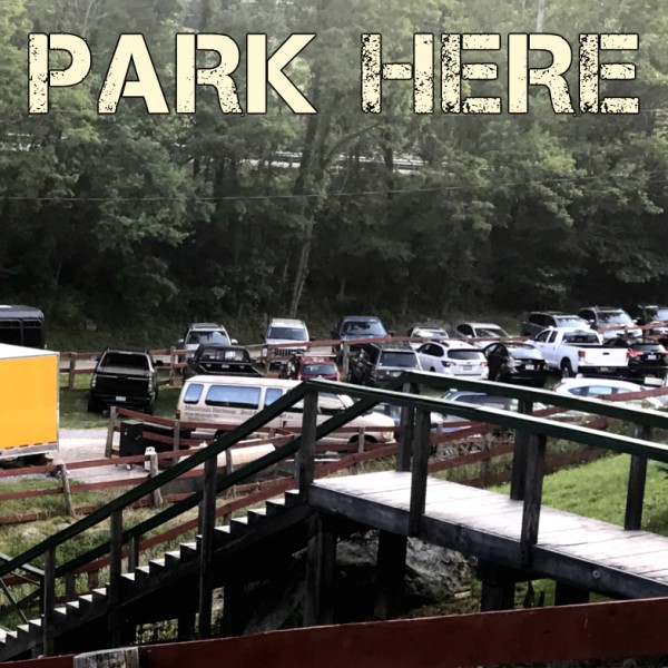 Parking lot at Mountain Harbour with cars and surrounding forested area.