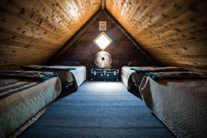 Cozy mountain cabin attic bedroom with two beds and vintage decor at Mountain Harbour.