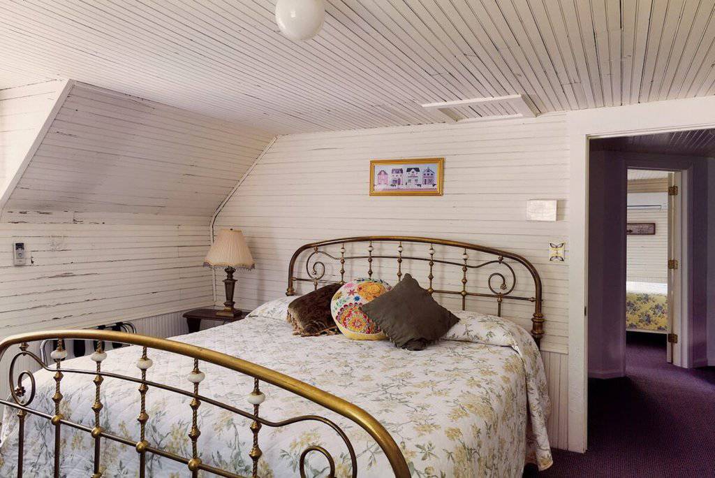 Cozy mountain harbour bedroom with antique brass bed and rustic decor.