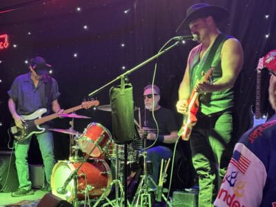 Mountain harbours live music performance with musicians playing guitars and drums at night.